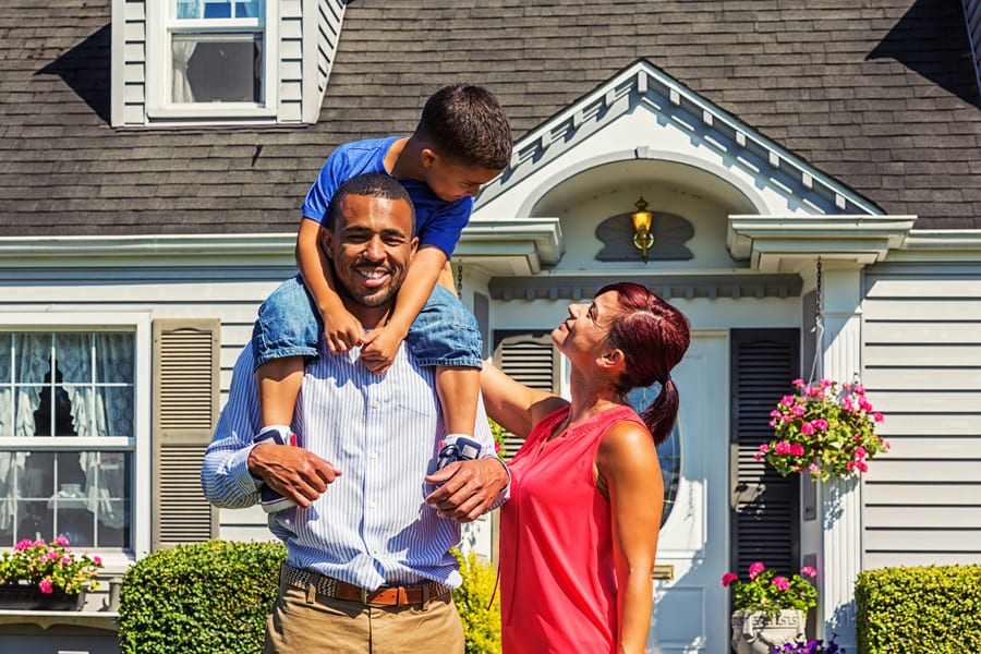 Happy family in front of home